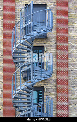 Strukturen der Stadt - Wendeltreppe an der Außenseite eines modernen Gebäudes. Stockfoto