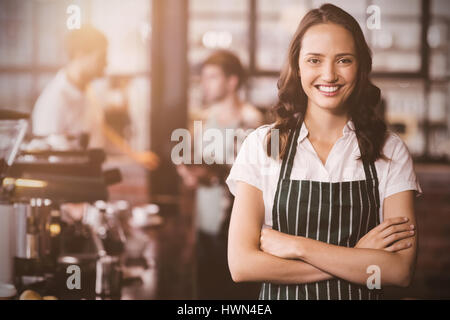 mit verschränkten Armen gegen hübsche Barista Flare Stockfoto
