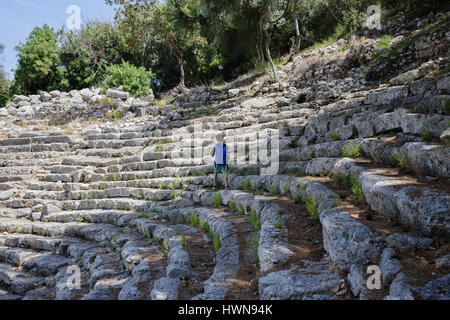 Tourist-junge trägt Shorts und Rucksack und Wandern auf Strairs des antiken Amphitheaters in Phaseslis Kemer Antalya Türkei Stockfoto