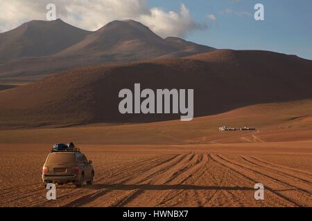 Bolivien, Potosi, Altiplano, désert Siloli, 4X4-Fahrzeug Durchqueren der Wüste der siloli auf 4600 m mit dem Hotel tayka del sesierto im Hintergrund Stockfoto