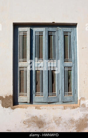 traditionellen alten Holzfenster in Rajasthan mit blauen verwitterten Lack und ausgefallenen Designs in ein Haus aus Beton Stockfoto