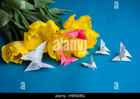 Bouquet von gelben Tulpen Closeup auf blauem Hintergrund mit Schmetterlingen Stockfoto