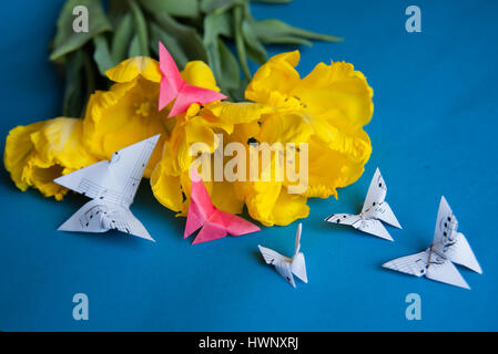 Bouquet von gelben Tulpen Closeup auf blauem Hintergrund mit Schmetterlingen Stockfoto