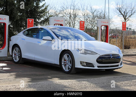 PAIMIO, Finnland - 18. März 2017: White Tesla Model S P85D Elektroauto wird in Tesla Kompressor aufgeladen. Die Kompressor-Stationen werden ca hinzufügen. Stockfoto