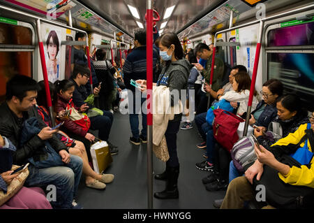 Passagiere, die Verwendung von Mobiltelefonen in der u-Bahn MTR Hong Kong, Hong Kong, China. Stockfoto