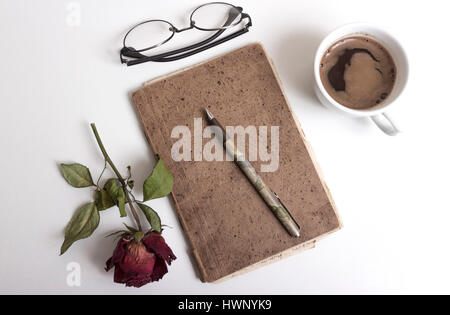 Notizbuch, Stift, Tasse Kaffee und rote rose auf Tisch. Kaffee-Pause Stockfoto