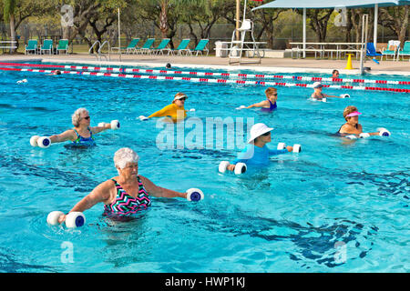 Gruppe von Frauen (verschiedene Altersstufen) Teilnahme an Wassergymnastik Klasse, mit "Wasser Hanteln'. Stockfoto