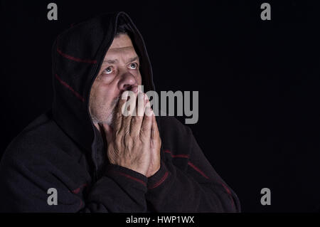 Schönes Portrait eines geistlichen senior Mannes in der Dunkelheit Stockfoto