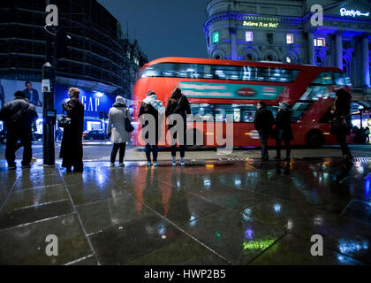 Londoner Routemaster Bus in Piccadilly Circus Leute im Regen stehen Stockfoto