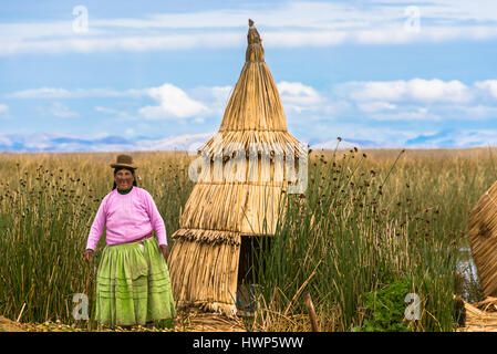 Die Uros sind ein indigenes Volk von etwa 4.000 Personen, die auf schwimmenden Inseln auf dem Titicacasee zu leben. Dies ist eine Frau vor ihrem Haus. Stockfoto