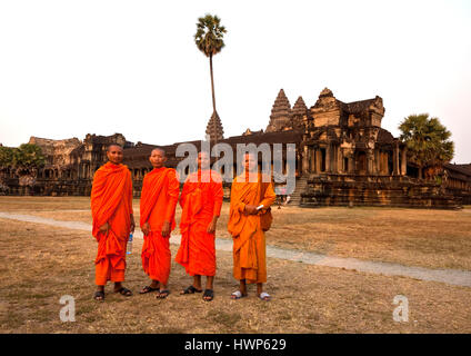 Vier Mönche in orangefarbenen Gewändern posieren vor Angkor Wat Stockfoto