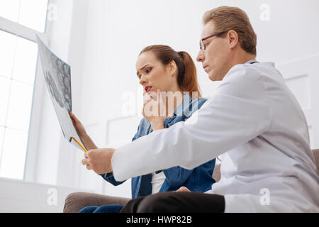 Das ist das Problem. Ausgezeichneten professionellen Arzt erklärt seinem Patienten warum sie benötigen sofortige Behandlung bei der Herstellung sicher She m bestimmt Stockfoto