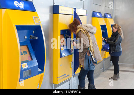 Utrecht, Niederlande, 15. März 2017: Frauen kaufen Tickets am Automaten am Hauptbahnhof Utrecht in den Niederlanden Stockfoto