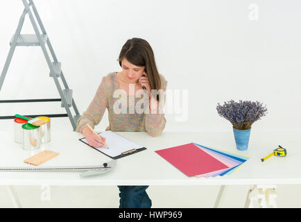 Kreative Menschen am Arbeitsplatz. Nahaufnahme der Brünette Junge Designer Frau mit Farbpalette am Schreibtisch arbeiten. Innenaufnahme. Horizontale Foto Stockfoto