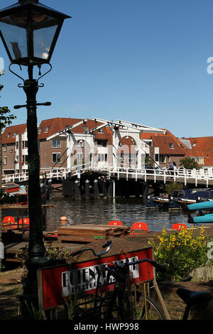 Leiden, Niederlande - Juli 3, 2014: Brücke hinter historischen gusseiserne Straßenlaterne mit Canal und historische Häuser in Leiden in den Niederlanden Zeichnen Stockfoto