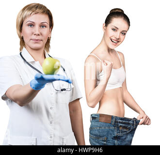 Arzt hält grünen Apfel. Junge Frau zeigt Gewicht-Verlust-Ergebnis. Gesunde Ernährung-Konzept. Stockfoto