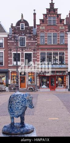 Delft, Niederlande - 2015, 24. März: eine Delfter Kuh in Richtung auf eine Königliche Delfter Keramik Steckdose über die Delft City Square suchen Stockfoto
