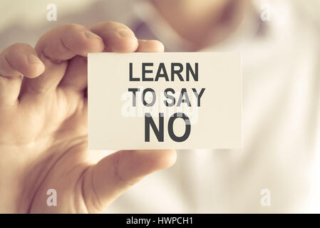 Closeup auf Geschäftsmann hielt eine Karte mit Text LEARN TO SAY NO, Firmen-Konzept-Image mit soft-Fokus-Hintergrund und Vintage-Ton Stockfoto