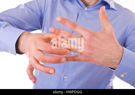 Mann seinen goldenen Ehering ausziehen. Stockfoto