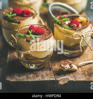 Hausgemachtes Dessert Tiramisu im Glas mit frischen Himbeeren an Bord Stockfoto