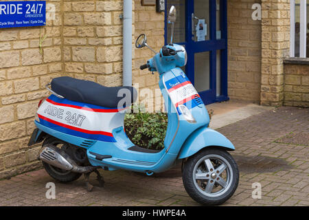 Cirencester - Fahrt 24/7 Moped geparkt außerhalb Fahrt 24/7 Fahrradladen am Woolmarket, Cirencester, Gloucestershire im März Stockfoto