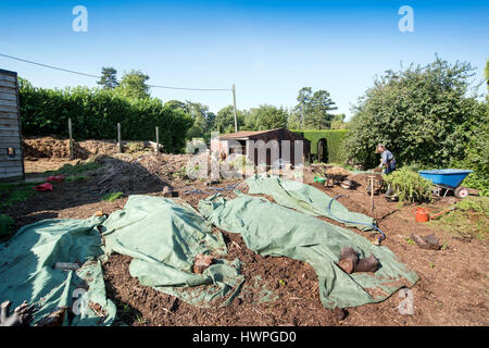 Das Land Gärtner Henrietta Courtauld und Bridget Elworthy machen Kompost im Wardington Manor in der Nähe von Banbury, Oxfordshire - Haufen Kompost unter gar Stockfoto