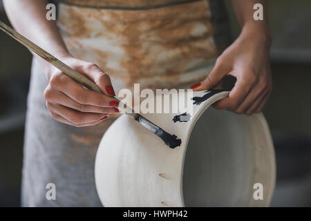 Mittelteil des weiblichen Potter Gemälde Ton Vase in Werkstatt Stockfoto