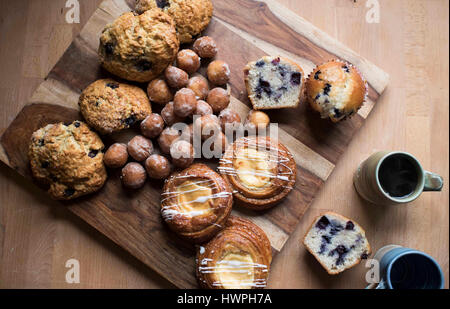 Erhöhte Ansicht von süßen Lebensmitteln mit Kaffee auf Holztisch Stockfoto