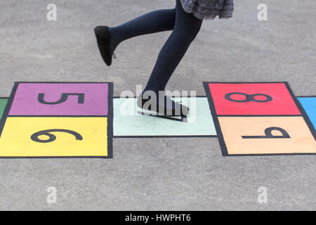 Mädchen spielen ich malte eine bunten Himmel und Hölle Spiel auf dem Bürgersteig Stockfoto