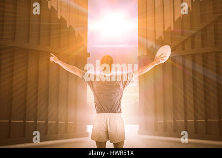 Rugby-Spieler gestikulieren mit den Händen gegen Fußballplatz mit Lichtern und Fahnen 3d Stockfoto