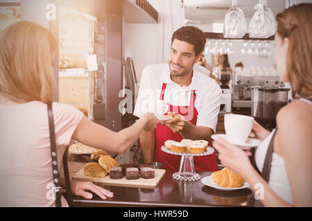 Grafik der Fackel gegen Freunde mit männlichen Barista am Schalter im Coffee-shop Stockfoto