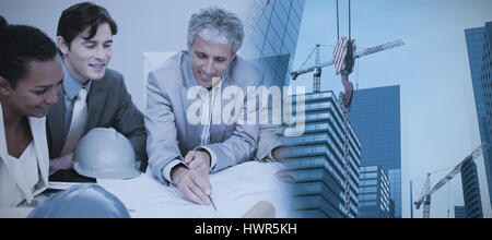 Studio schießen eines Krans gegen Konstruktoren treffen Pläne zu studieren Stockfoto