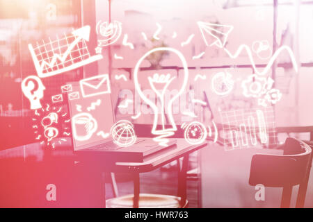 Laptop auf dem Tisch gegen digital generierte Bild der Glühbirne inmitten Business Symbole 3d Stockfoto