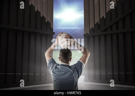 Rugby-Spieler zu einen Rugby-Ball gegen Fußballplatz mit Lichtern zu werfen und Fahnen 3d Stockfoto