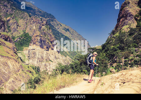 Frau Backpacker Klettern mit Rucksack im Himalaya, Nepal. Trekking und Wandern mit Rucksack im Hochgebirge. Annapurna Himal Range auf Annapurna C Stockfoto