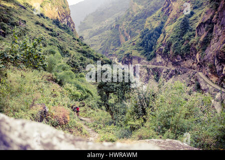 Weibliche Backpacker Klettern mit Rucksack im Himalaya, Nepal. Trekking und Wandern mit Rucksack im Hochgebirge. Annapurna Himal Palette am Annapurna Stockfoto