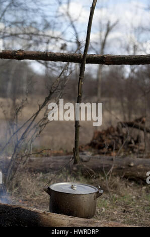 Kochen in alten rußigen Kessel am Lagerfeuer im Wald Stockfoto