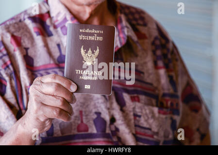 Hand, die thailändische Reisepass am Flughafen Stockfoto