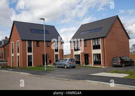 Neuen roten Backsteinhäuser mit solar Schwarz pv Panels persimmon greenacres Bishops Cleeve Cheltenham uk Stockfoto