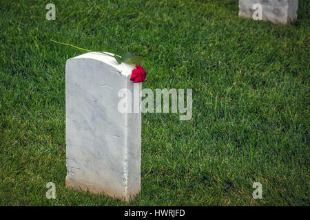 Am Tag nach dem Memorial Day 2016 auf einem südlichen California Militärfriedhof, die Rückseite eines Grabes mit einer Rose ruht an der Spitze. Stockfoto