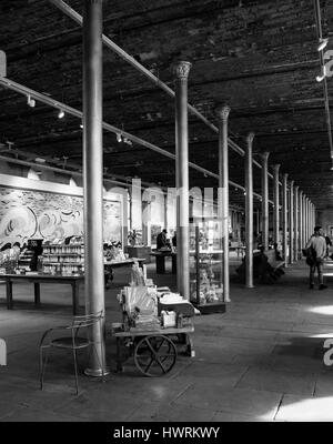 Ein schwarz-weiß Foto des Innenraums von Salts Mill in Saltaire.  David Hockney Drucke sind zu sehen, zusammen mit Kunstmaterialien und Keramik. Stockfoto