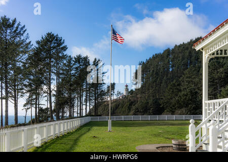 Der grasbewachsene Rasen der Heceta Head Light Station Bed and Breakfast hat einen ausgezeichneten Blick über den weißen Zaun hinaus auf die Küste von Oregon. Stockfoto