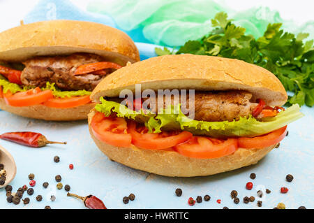 Sandwich: Fleisch mit Gemüse in einem Brötchen mit Tomaten und Kopfsalat Blätter Rollen. Stockfoto