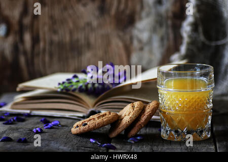 Retro-Buch und ein Glas Orangensaft morgens Stockfoto