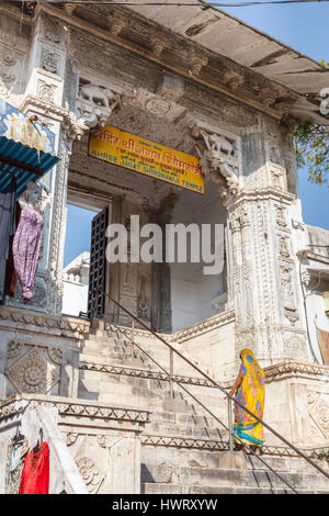 Indische Frau in typischen Sari aufsteigend die Stufen am Eingang des hinduistischen Shree Jagat Sheromani-Ji-Tempel, Udaipur, Rajasthan, Indien Stockfoto