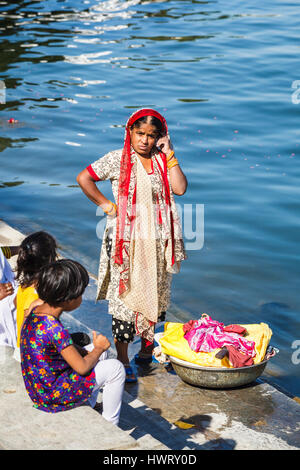 Indische Frau tut ihr waschen und Kinder auf See Ufer des Pichola-See, Udaipur, indischen Bundesstaat Rajasthan Stockfoto