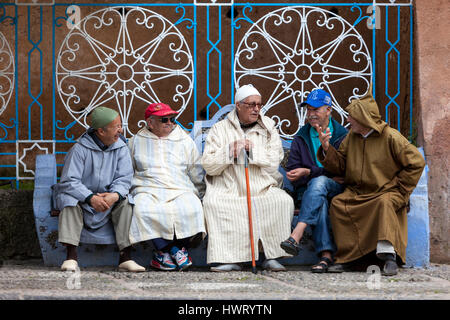 Chefchaouen, Marokko.  Männer sprechen auf dem öffentlichen Platz, demonstriert eine Vielzahl von traditionellen und westlichen Kleidungsstil. Stockfoto