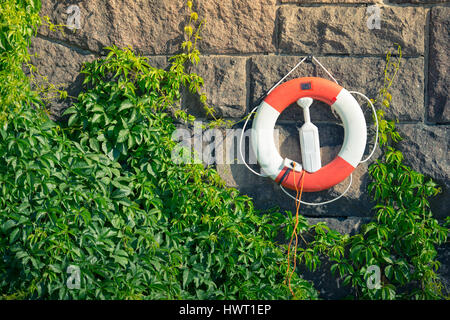 Rettungsring auf Steinmauer im Waterfront in Stockholm, Schweden, Skandinavien, Europa. Stockfoto