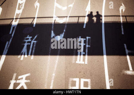 Vogelperspektive anzeigen von japanischem Text unterwegs mit Schatten von Menschen auf der Brücke Stockfoto