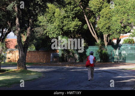 Schwarzen Arbeiter Fuß zur Arbeit durch einen Vorort in Südafrika nach der Apartheid aufgrund des Fehlens von ÖPNV-Infrastruktur Stockfoto